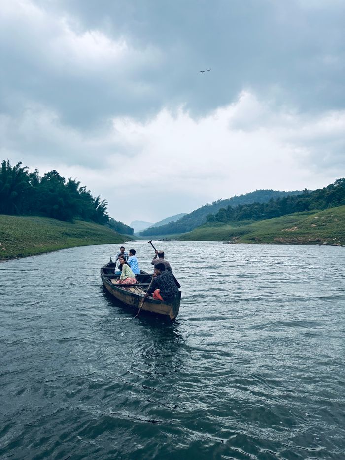 Scenic boat ride on a serene river surrounded by lush greenery in Idukki, Kerala
