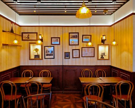 Warm and inviting restaurant interior featuring vintage decor, classic wooden chairs, and ambient lighting.