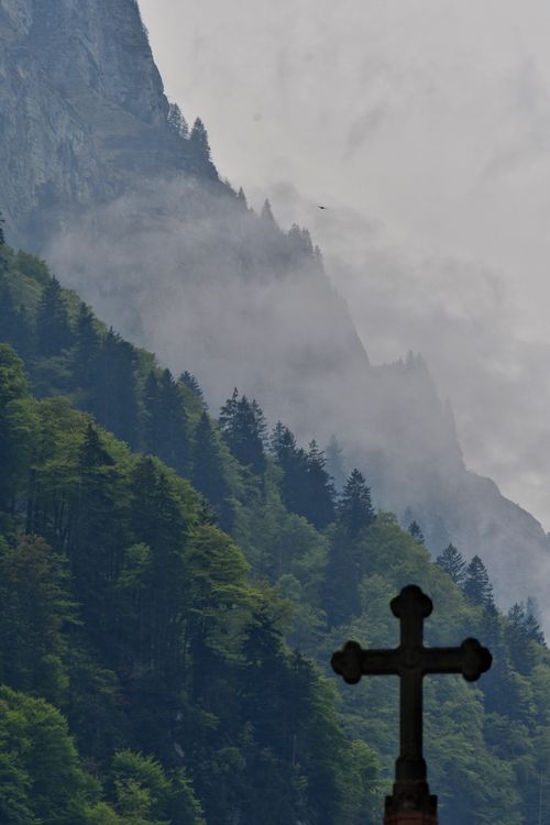 Free A misty mountain scene with a prominent cross in the foreground. Stock Photo