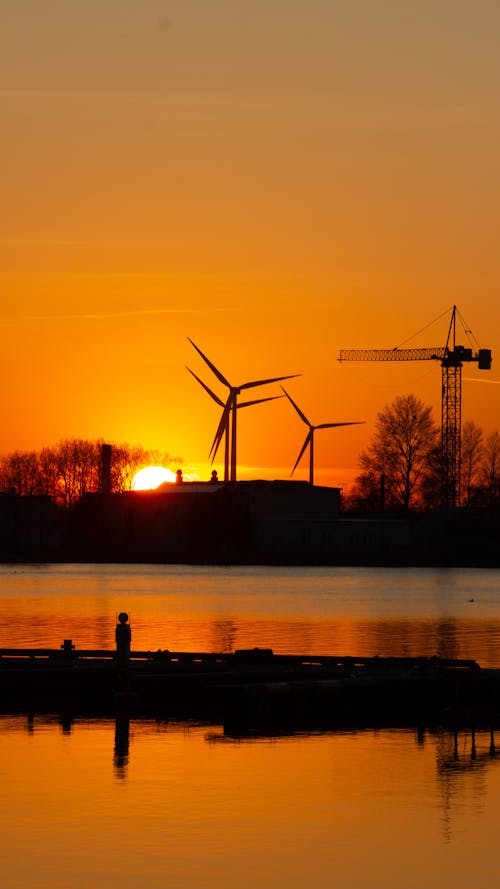 Wind Turbines and Construction Crane at Sunset