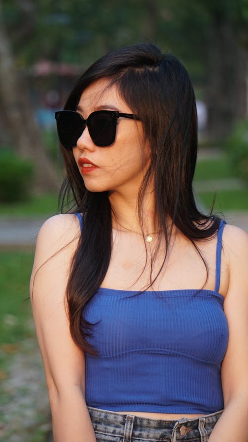 Young Brunette Wearing Sunglasses Sitting Outdoors 