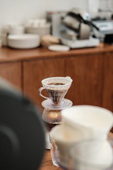 Close-up of pour over coffee being brewed in a cozy cafe environment, highlighting the brewing process.