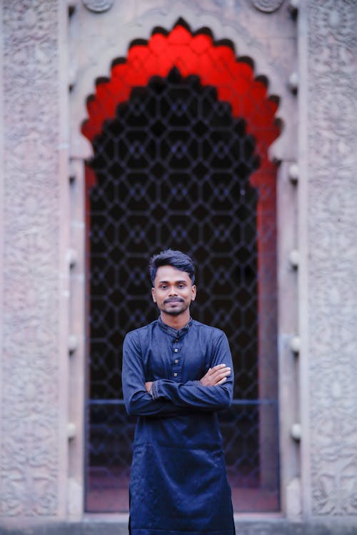 Young Man Wearing a Kurta and Standing in front of a Mausoleum 