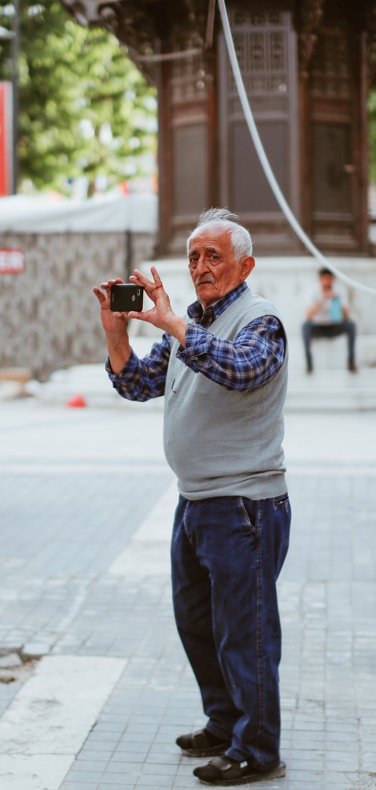 Old Man Taking Picture With Cellphone On Street