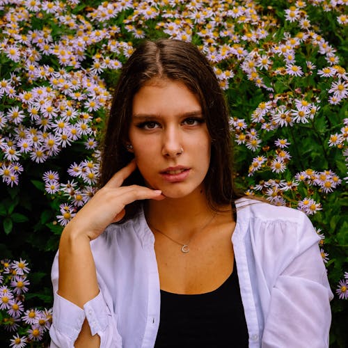 Mujer En Camisa Blanca De Pie Delante De Flores Blancas