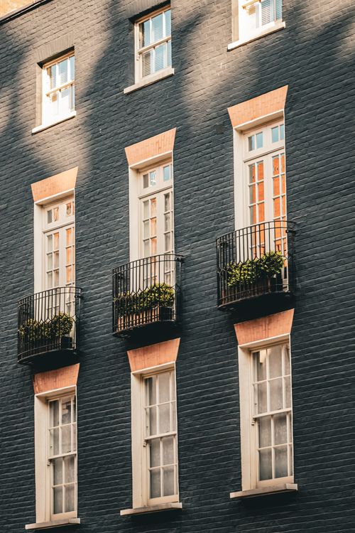 Free A stylish urban building facade in London featuring multiple balconies and windows. Stock Photo