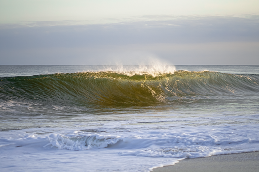 Calm ocean waves gently crashing on Rocha Beach, Uruguay, at sunset.