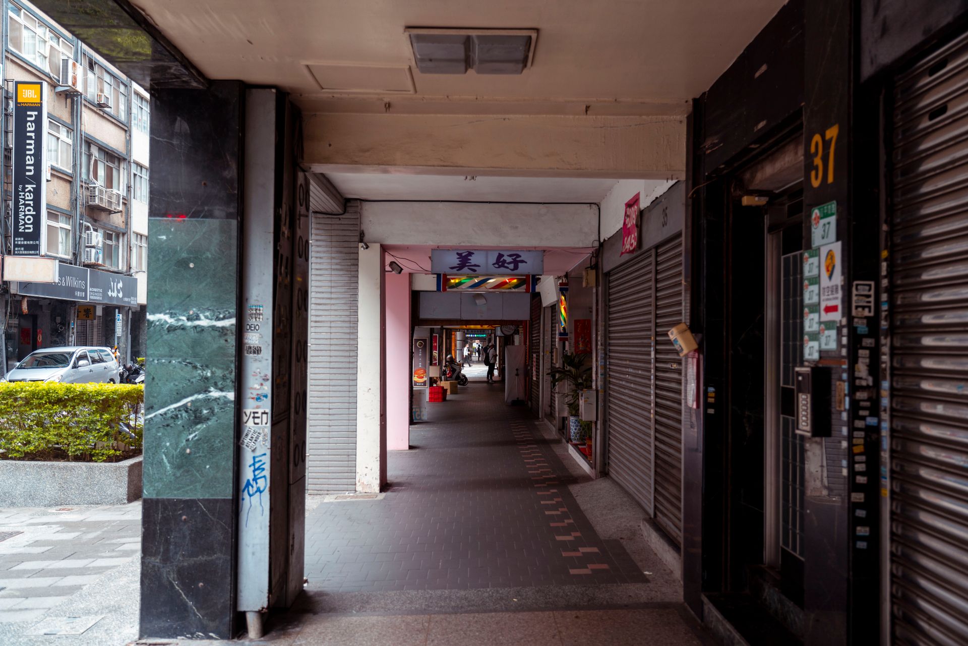 A deserted passage with closed shops in an Asian city, highlighting urban solitude.