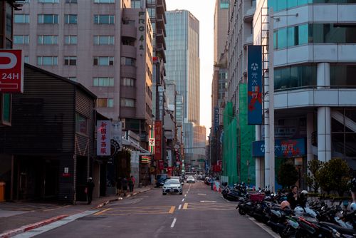 Free Dynamic city street scene with modern buildings, cars, and motorcycles in an Asian urban area. Stock Photo