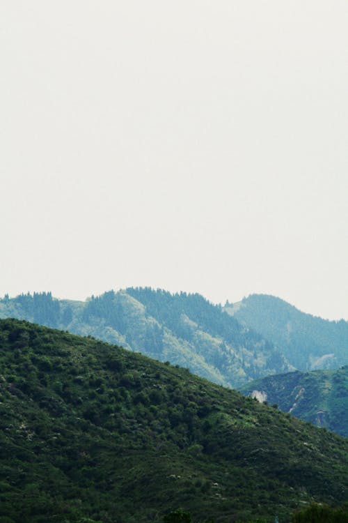 Landscape of Green Mountains under a Cloudy Sky 