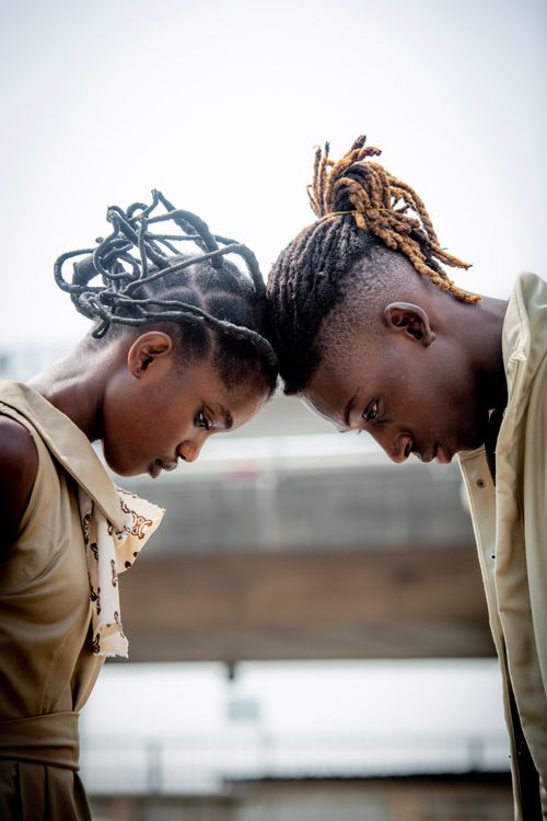 Free Two individuals with distinct dreadlocks pose intimately in an urban setting, showcasing fashion and style. Stock Photo