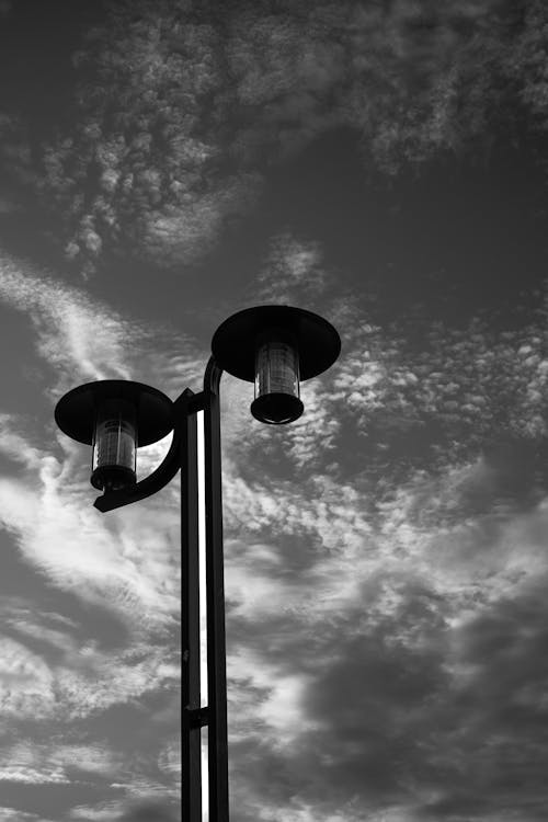 Black and White Photo of a Street Lamp Against a Cloudy Sky