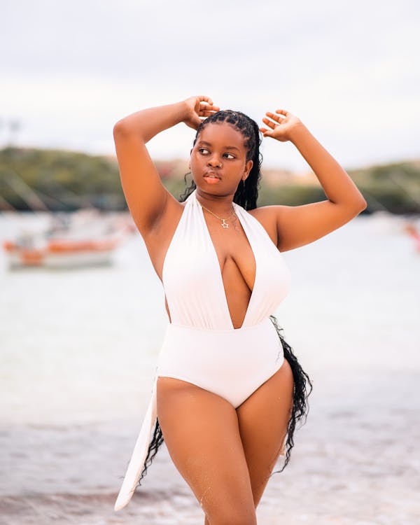 Young Woman in a White Swimming Costume Posing on the Beach 