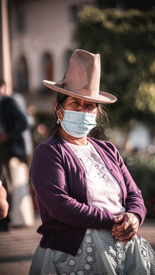 Free A woman wearing a traditional hat and mask stands confidently, reflecting cultural elegance. Stock Photo