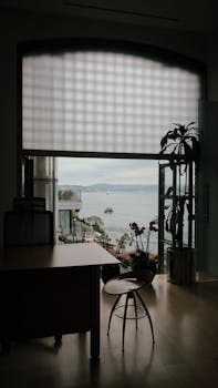 A contemporary apartment's interior features a stunning sea view through a large window.