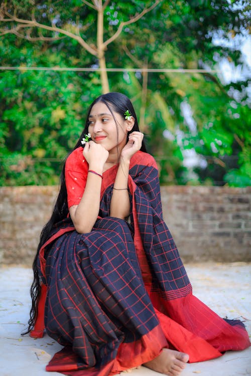 Young Woman in a Traditional Dress Sitting Outdoors 