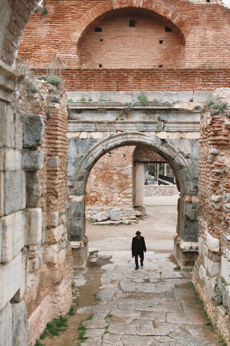 High Angle Shot Of A Man Walking In An Alley Between Old Buildings 