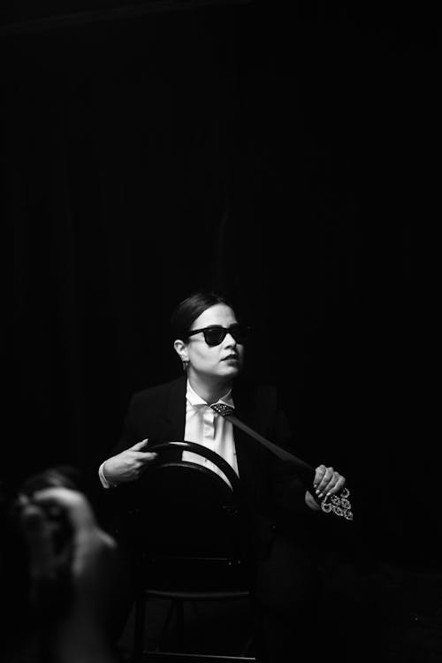 Studio Shot of a Young Woman in a Suit and Sunglasses 
