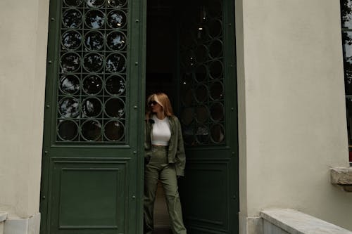Young Woman Walking out of a Building through Old Door 