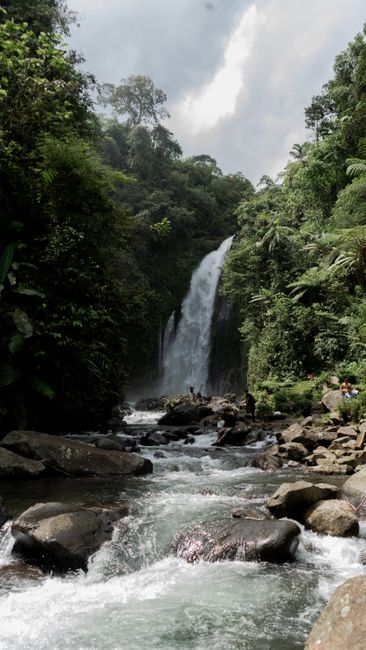 Stunning waterfall surrounded by lush greenery in Indonesia's tropical forest.