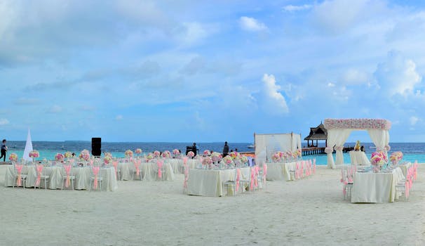 Elegant beach wedding setup with pastel floral decor and ocean view.