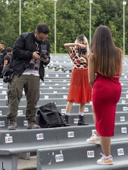 Two photographers capturing a model in a vibrant outdoor setting.
