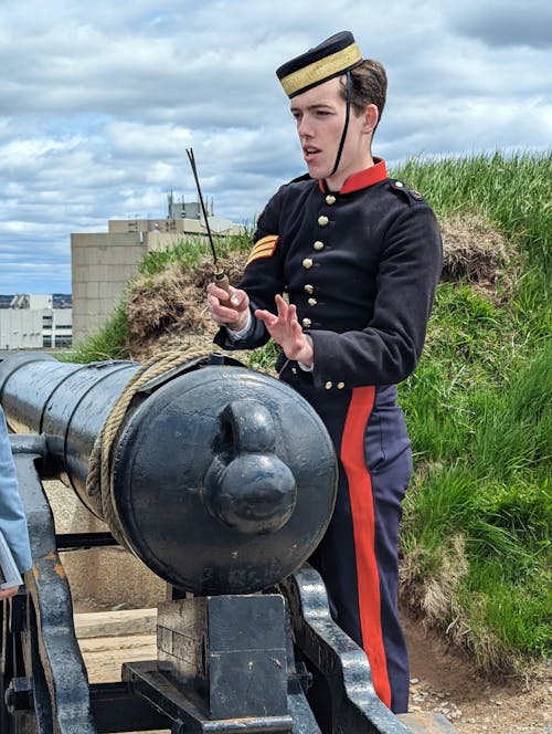 Man in Uniform Standing with Cannon