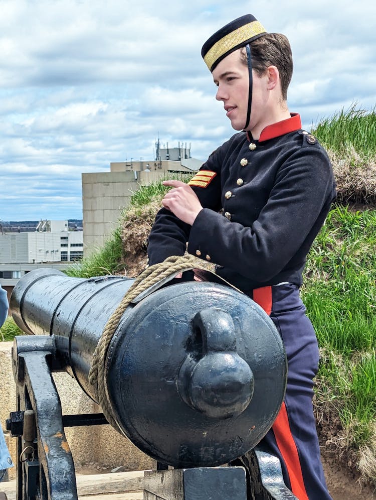 Soldier In Formal Uniform Stands By Cannon