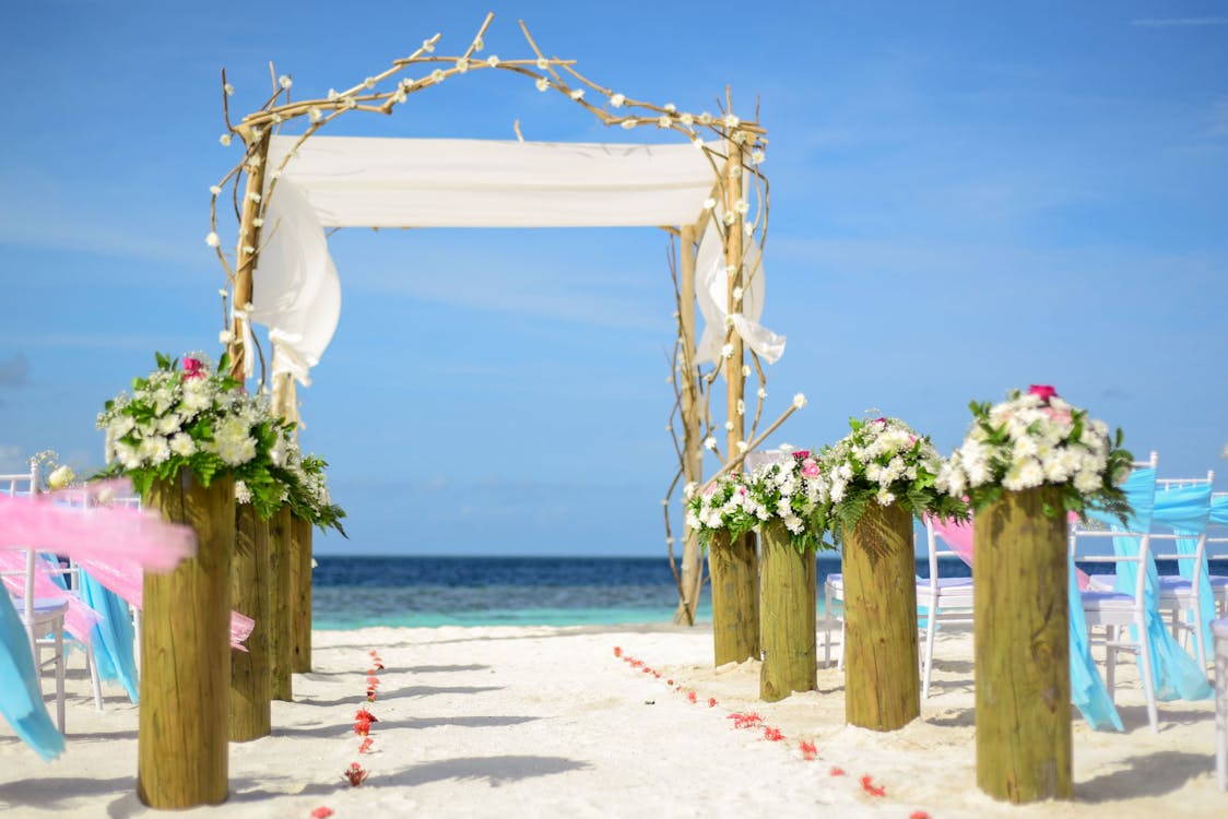 Line of White Flowers-topped Brown Wooden Pillars