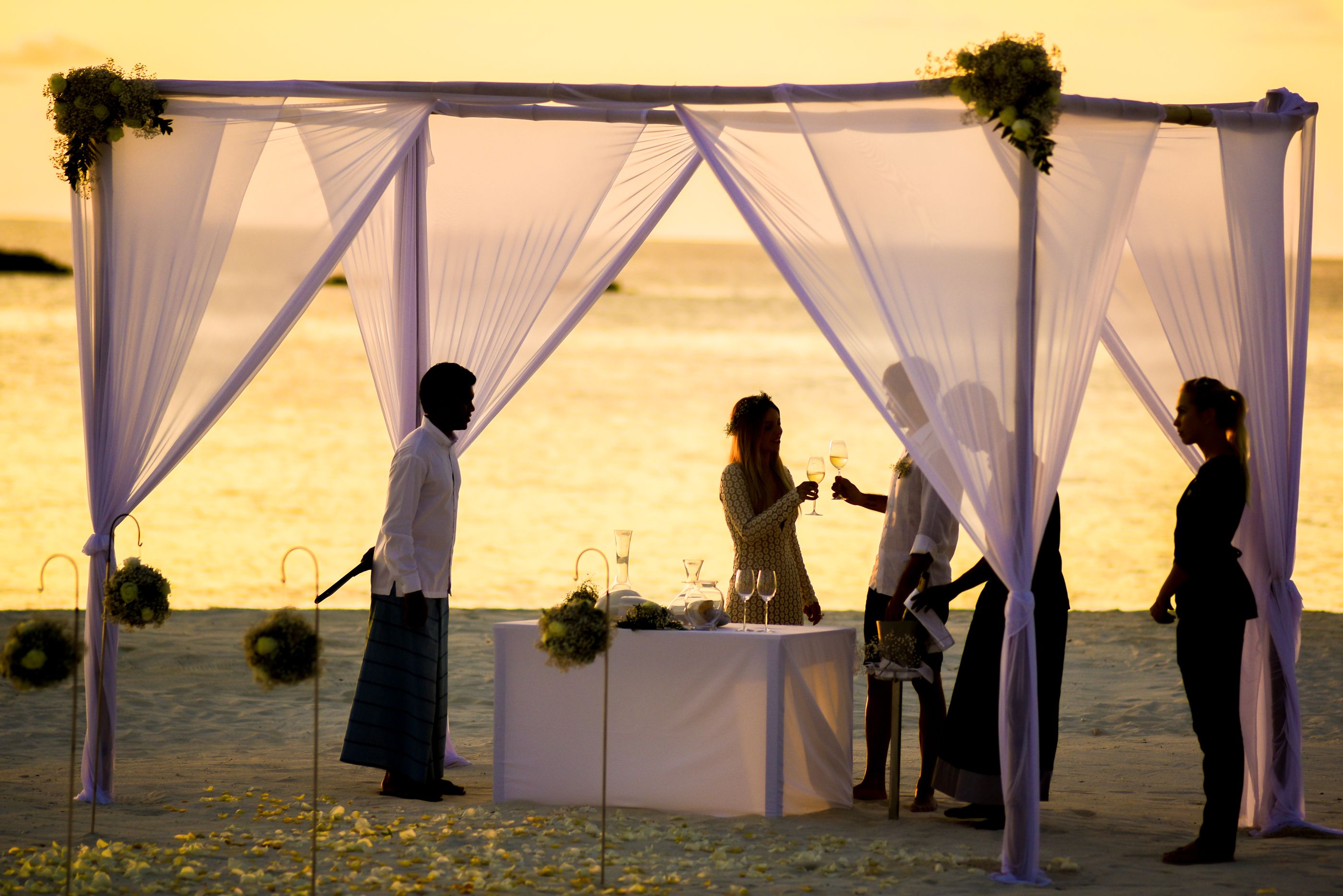 Installation de mariage sur une plage au coucher du soleil face à l'océan