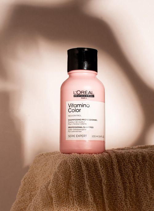 Free Stylish luxury shampoo bottle with shadow play on textured fabric, ideal for beauty and wellness themes. Stock Photo