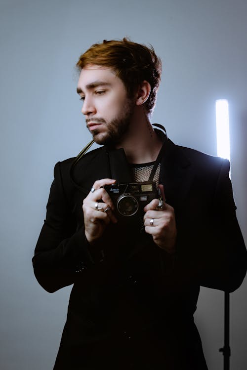 Portrait of Man in Black Suit and with Camera