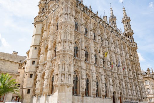 Low angle view of the ornate Gothic facade of Leuven Town Hall in Belgium.