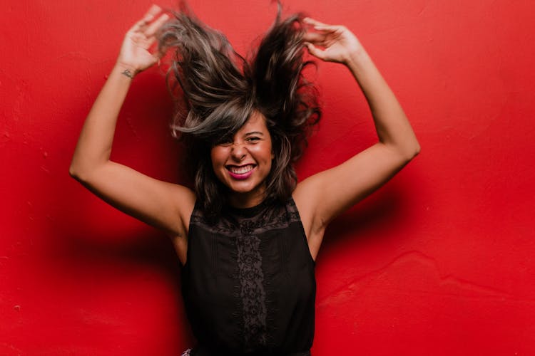 A Woman Posing On A Red Background