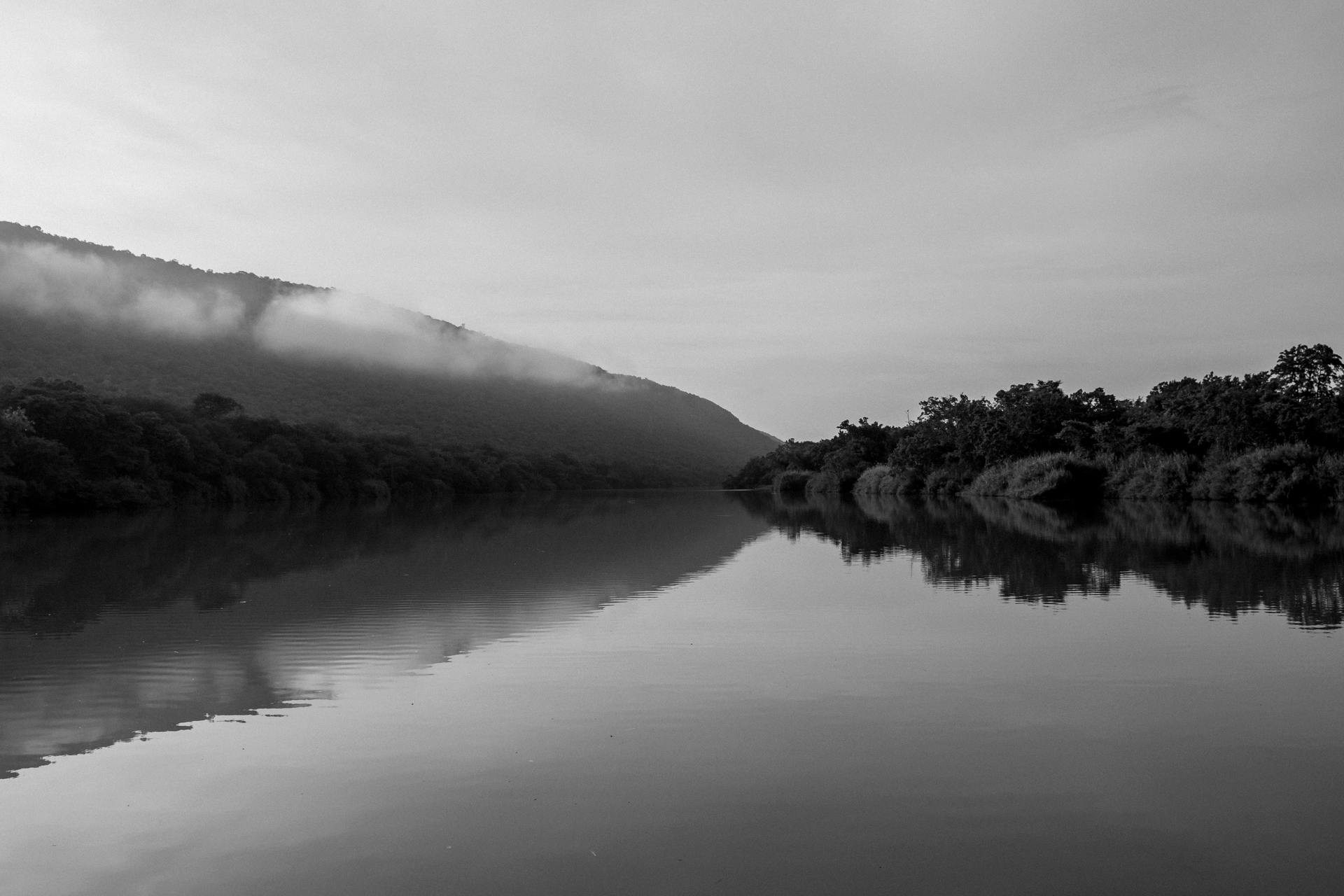 A serene black-and-white landscape of mountains and river in Komatipoort, South Africa.