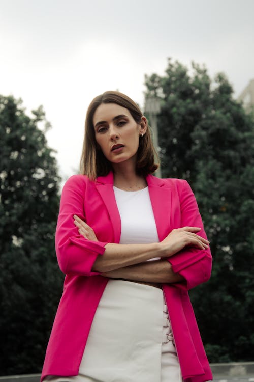 Woman in a Pink Suit Jacket Standing with her Arms Crossed