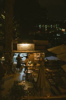 Charming outdoor cafe scene at night with ambient lighting and patrons enjoying the warm atmosphere.