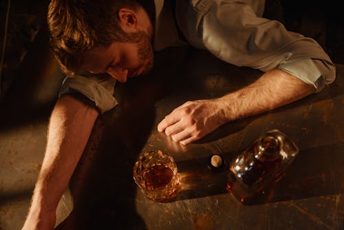 Ein Mann Schläft Mit Einer Flasche Whiskey Auf Einem Tisch