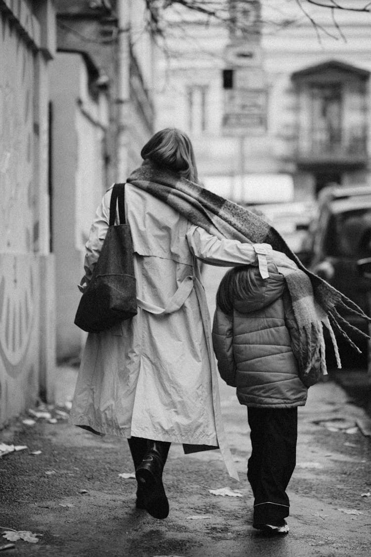 Mother And Child Walking On Sidewalk In Black And White