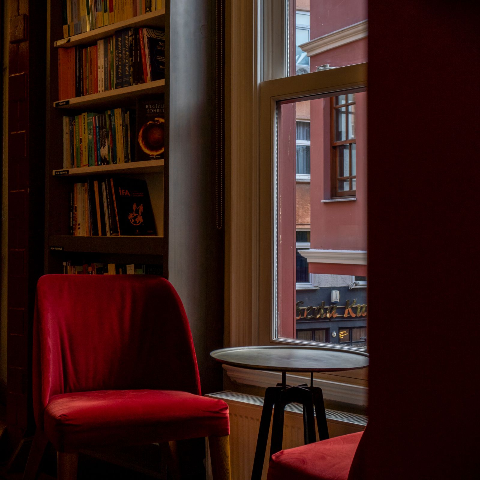 Cosy lounge with red armchairs and bookshelves