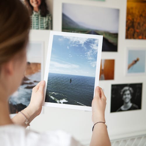 woman holding a wall art print in front of a gallery wall