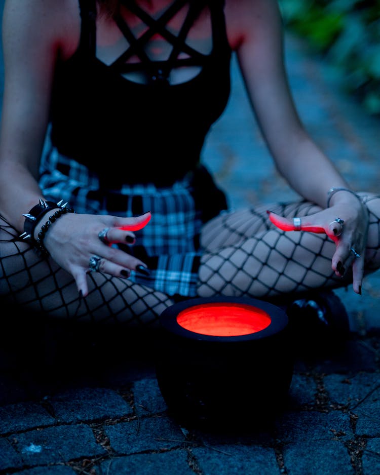 A Witch Sitting On The Ground With A Pot 