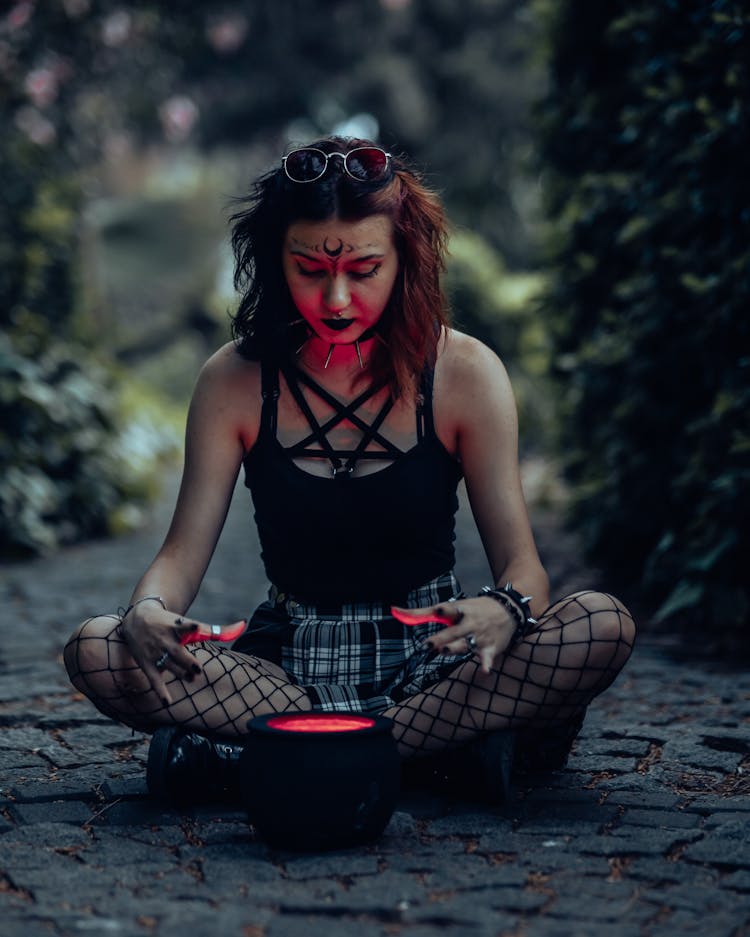 A Witch Sitting On The Ground With A Pot 