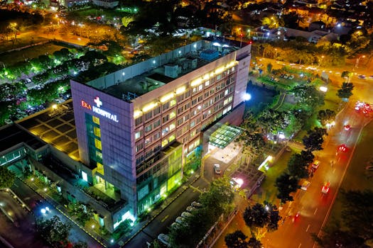 Stunning aerial view of Eka Hospital in Serpong, Indonesia, illuminated at night, capturing vibrant city lights and architecture.