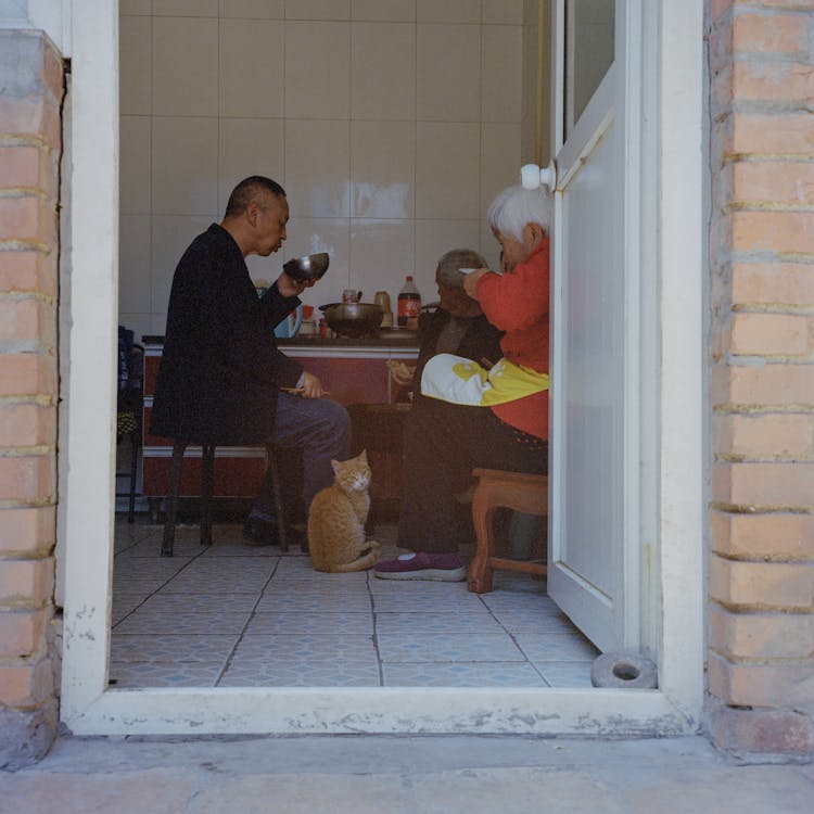 A Group Of People Sitting In The Kitchen 