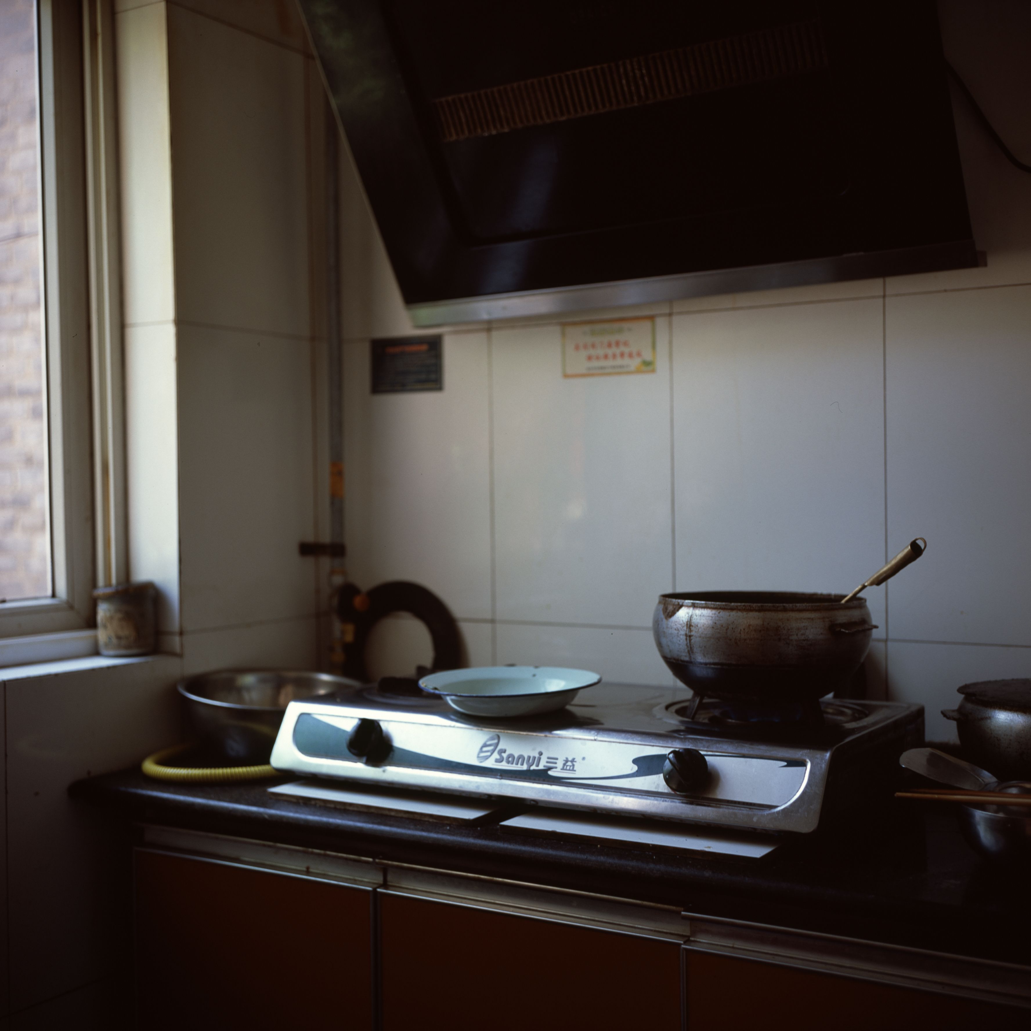 A small kitchen stove with pots and pans in a cozy interior setting, ideal for domestic and home themes.
