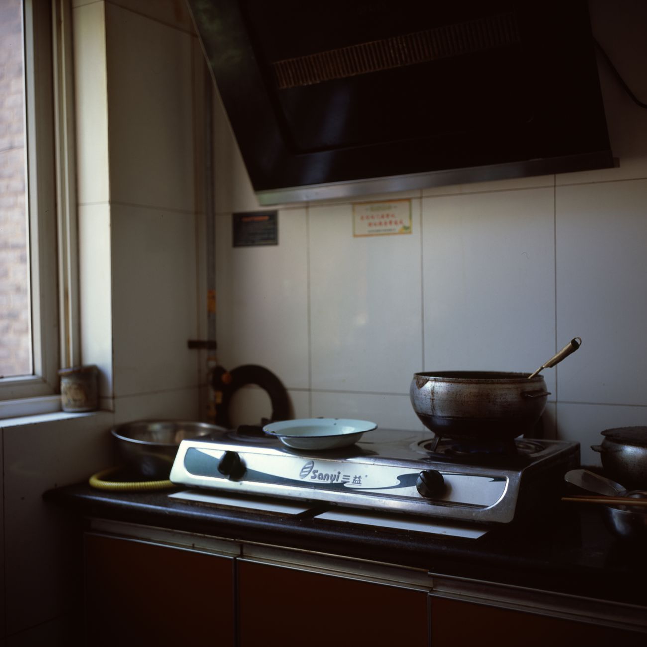 A small kitchen stove with pots and pans in a cozy interior setting, ideal for domestic and home themes.