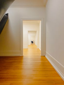 A bright hallway in Bilbao with wooden floors and white walls, showcasing a minimalist style.