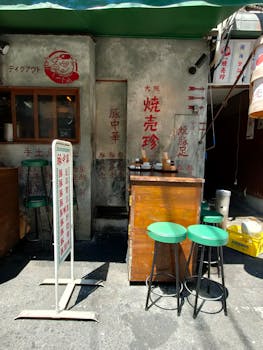 Authentic Japanese street food stall with green stools and traditional decor.
