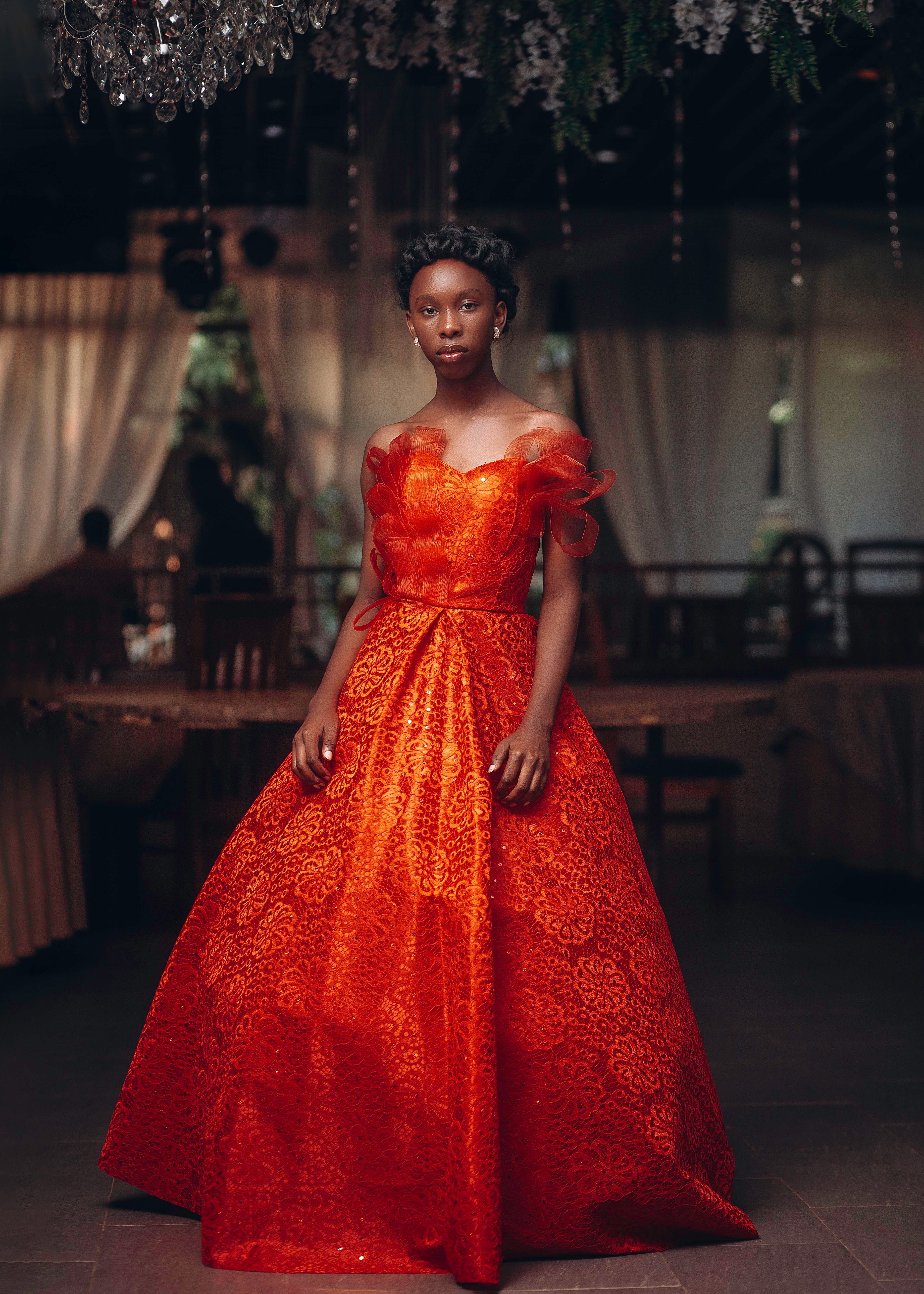 Stunning fashion portrait of an African woman in a red gown, showcasing elegance and style indoors.